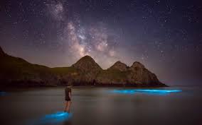 une personne marche sur l'eau bioluminescence lumière-Atlaneastro