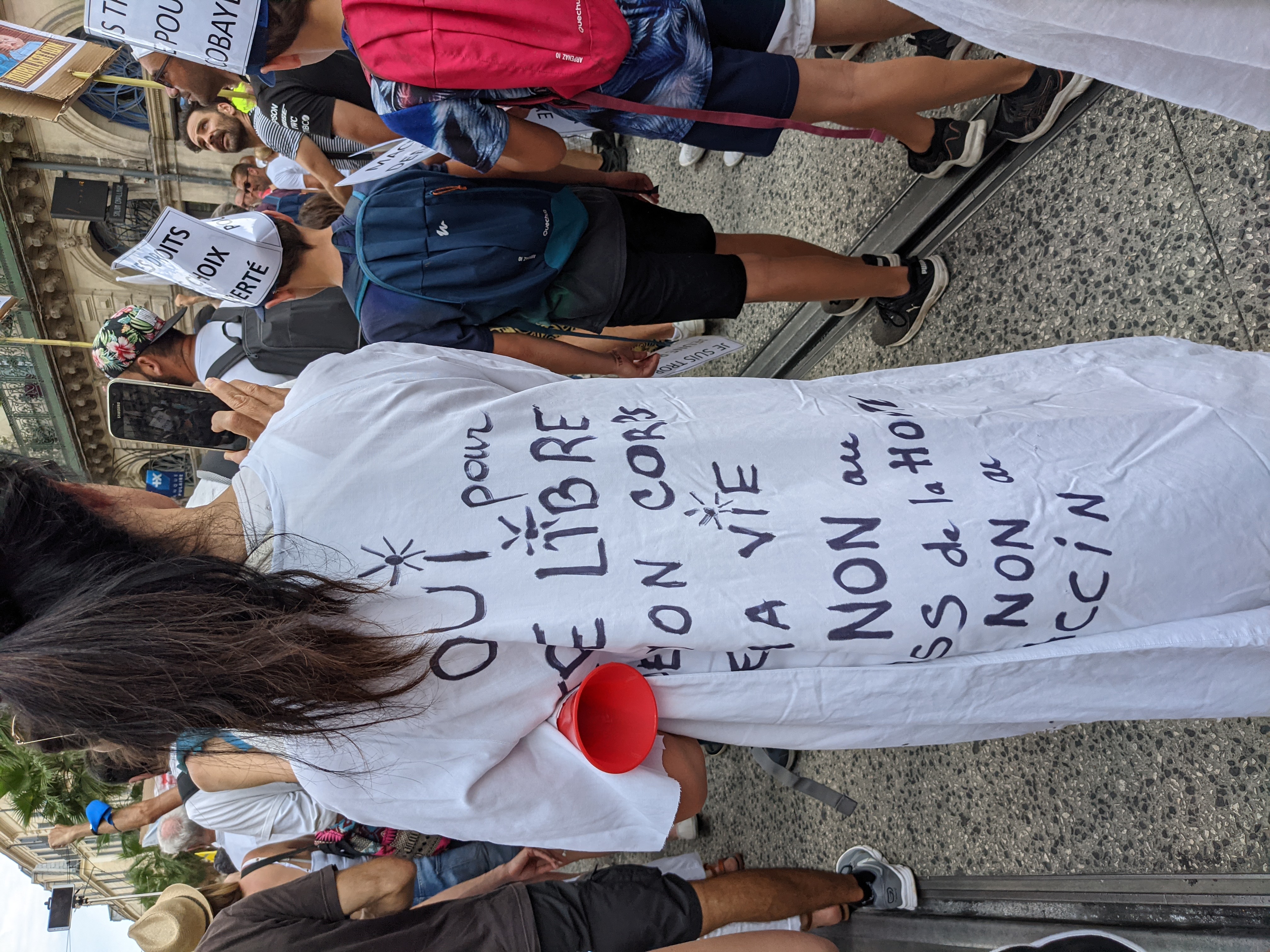 conscience manifestation anti pass sanitaire France une femme porte un robe blanche sur laquelle sont écrit ses revendications Part.3-Atlaneastro